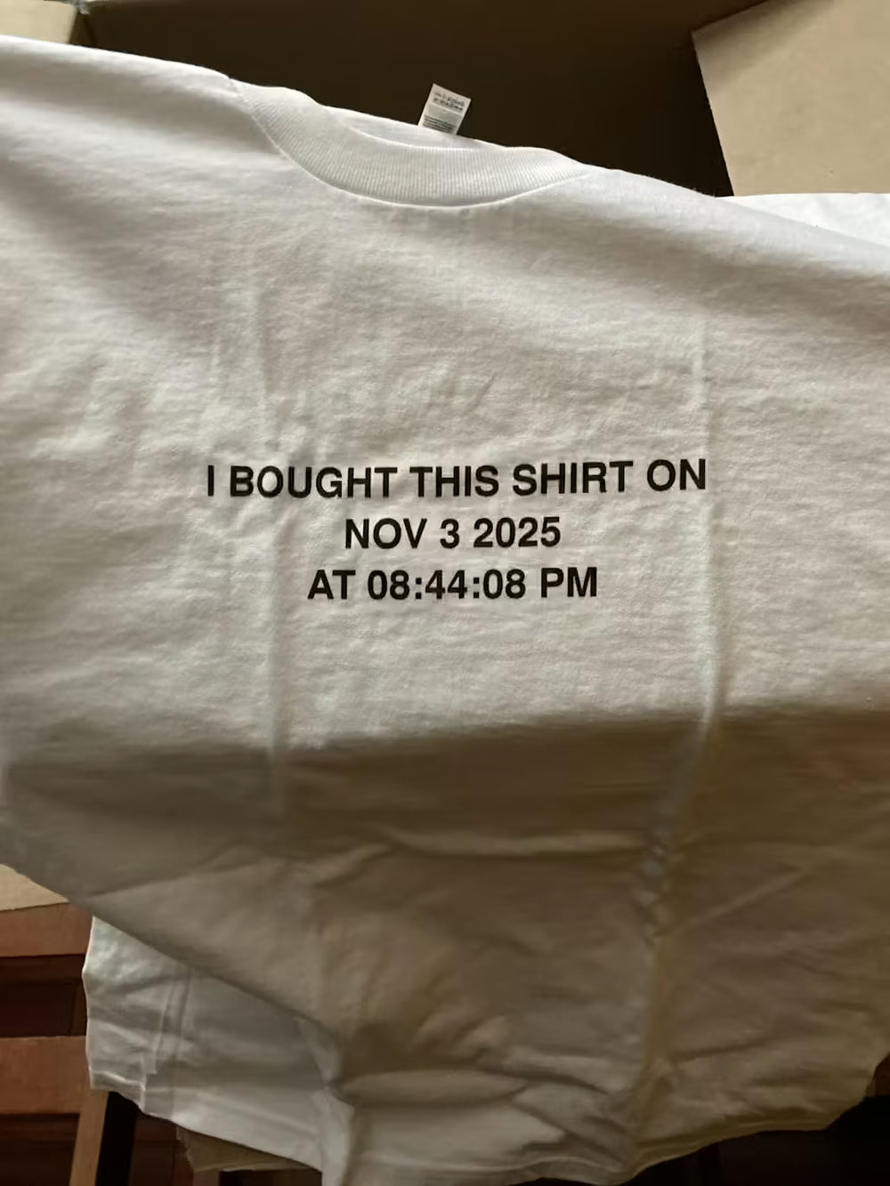 White shirt with timestamp printed on it, displayed against a neutral background.