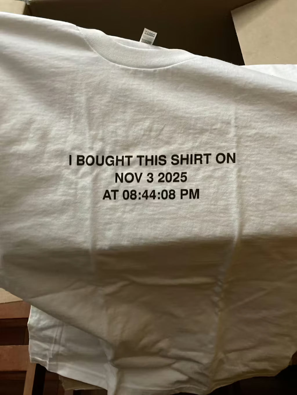 White shirt with timestamp printed on it, displayed against a neutral background.